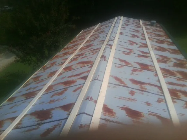 Rusted metal roof panels with new wood purlins before replacement — Storm Damage Roof Repair in Lobelville by Roofing Brothers