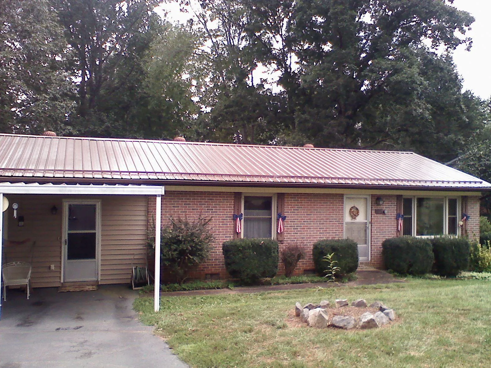 Bronze metal roof and carport on a brick ranch home — Roof Repair work by our crew in Lobelville