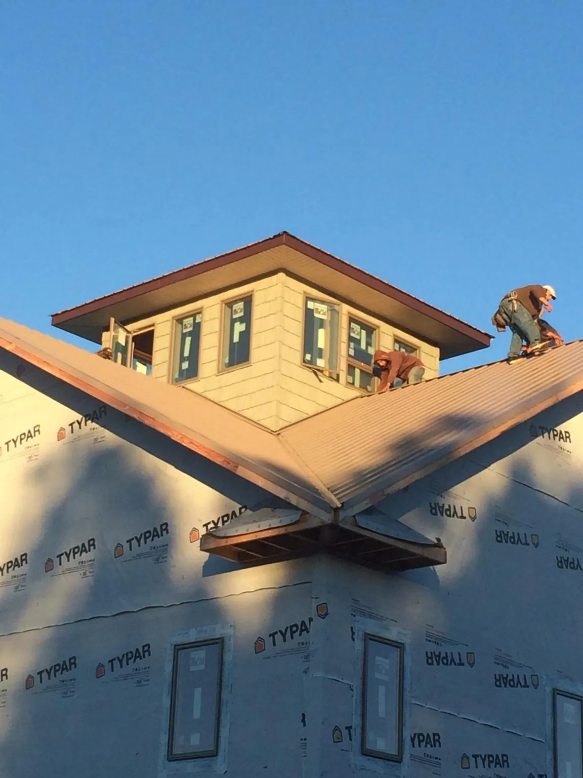 Roofers working around a rooftop cupola on a new metal roof at sunset — Roof Waterproofing in Lobelville by Roofing Brothers